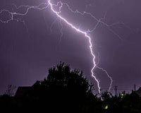 Lightning strike in the night sky during a thunderstorm over a campsite in Australia.
