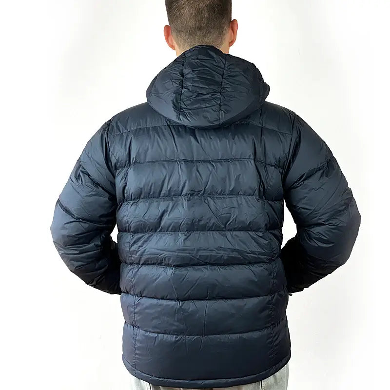 Load image into Gallery viewer, Man wearing Sherpa Men's Midweight 650+ Hooded Down Jacket showing back view of navy blue puffer with hood raised