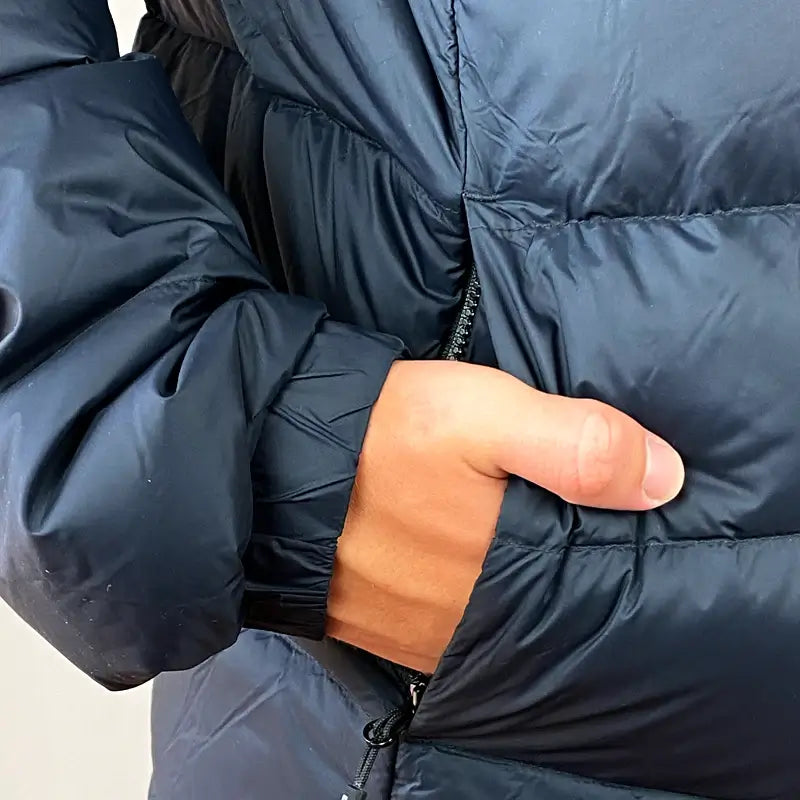 Load image into Gallery viewer, Close-up of hand in pocket of Sherpa Men's Midweight 650+ Hooded Down Jacket showing premium 33D Nylon shell