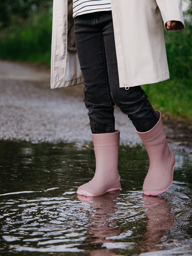 Load image into Gallery viewer, Child wearing Be Lenka Kids Barefoot Rain Boots in Misty Pink while playing in puddles outdoors.