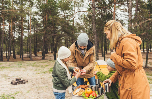 Family enjoying outdoor meal while camping in the forest