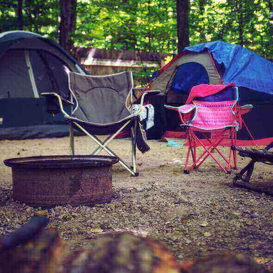 Camping site in Australia with tents and camping chairs surrounded by forest scenery