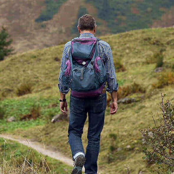 Person hiking through scenic Australian landscape with a backpack, embracing sustainable wildlife encounters.