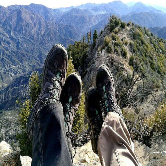 Hiking boots against a scenic mountain vista, embodying the spirit of adventure and the Leave No Trace hiking principles.