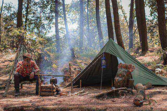 Camper enjoying an eco-friendly camping trip in a forest with a tent, campfire, and sustainable gear.