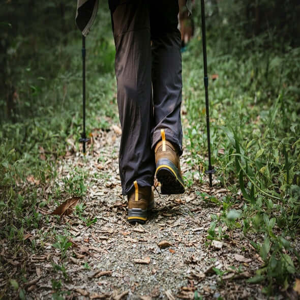 Person wearing trail running shoes on a forest path surrounded by greenery, promoting outdoor fitness.
