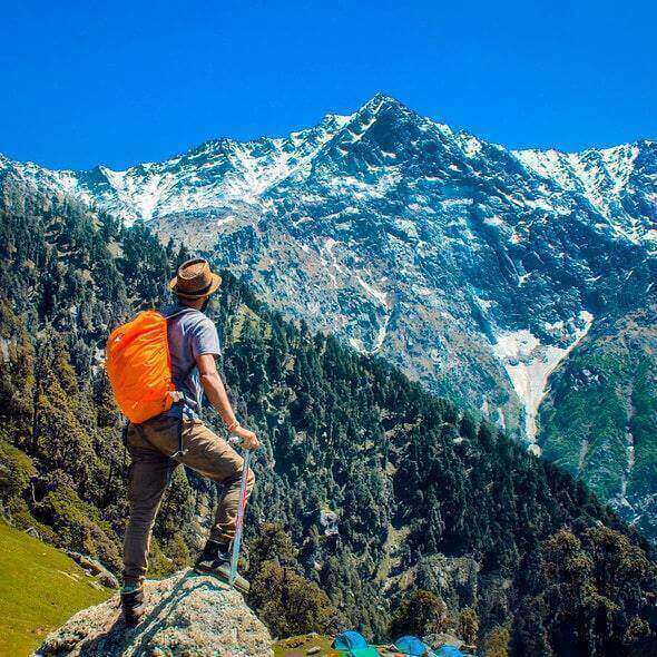 Man wearing outdoor hiking pants and backpack enjoying a scenic mountain view