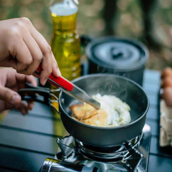 Cooking breakfast on a portable camping stove in the outdoors