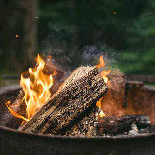 Campfire burning wood inside a portable fire pit suitable for camping trips.