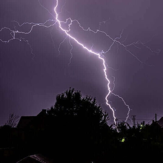 Lightning strike in the night sky during a thunderstorm over a campsite in Australia.