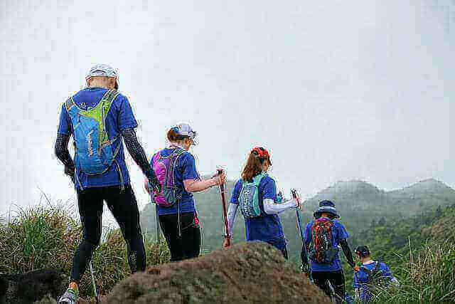 Group of hikers on a misty trail practicing sustainable outdoor habits