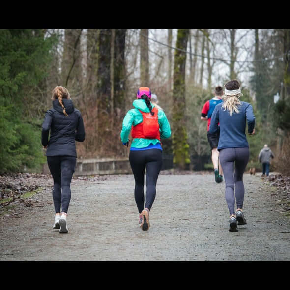 a-group-of-people-running-down-a-dirt-road