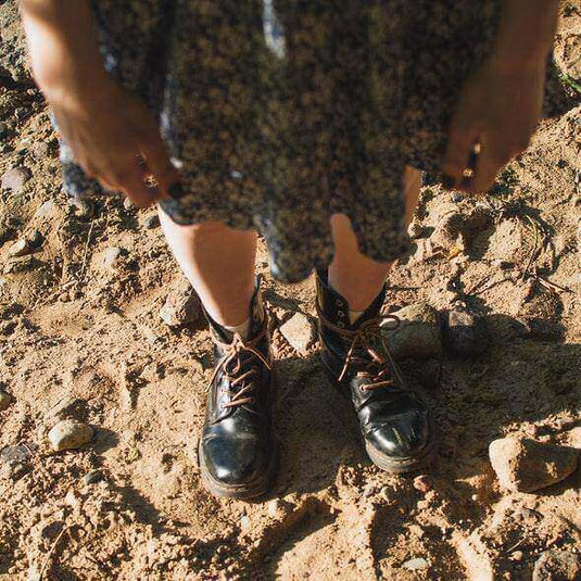 Person standing on rocky terrain wearing snake boots for protection against snake bites during outdoor activities like hiking.