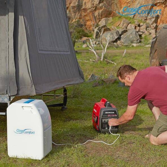 Man setting up portable Coolzy air conditioner next to tent, demonstrating ease of use and no-hassle installation outdoors