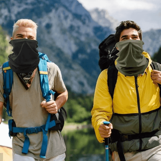 Two hikers wearing Adventureco neck warmers and scarves for warmth and protection on a mountain trail.